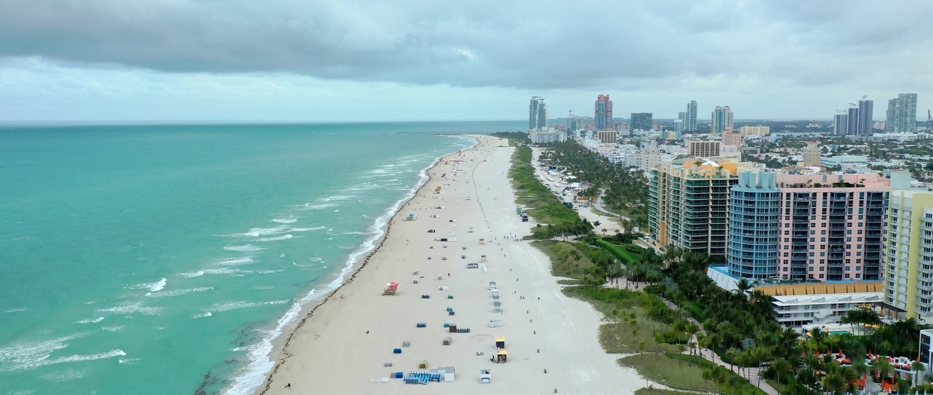 an aerial view of a beach with a city in the background