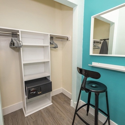 a closet with a safe and a mirror on the wall