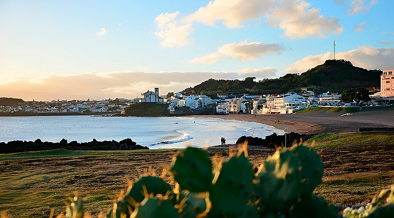 Town square with Sul Villas & Spa hotel, church, and trees in Azores, Portugal.