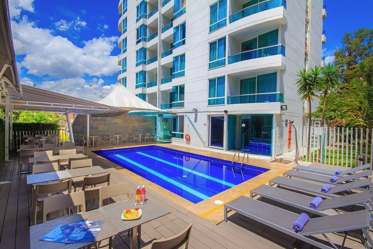 Summum: Poblado Suites - Piscina del hotel con zona de estar y tumbonas.