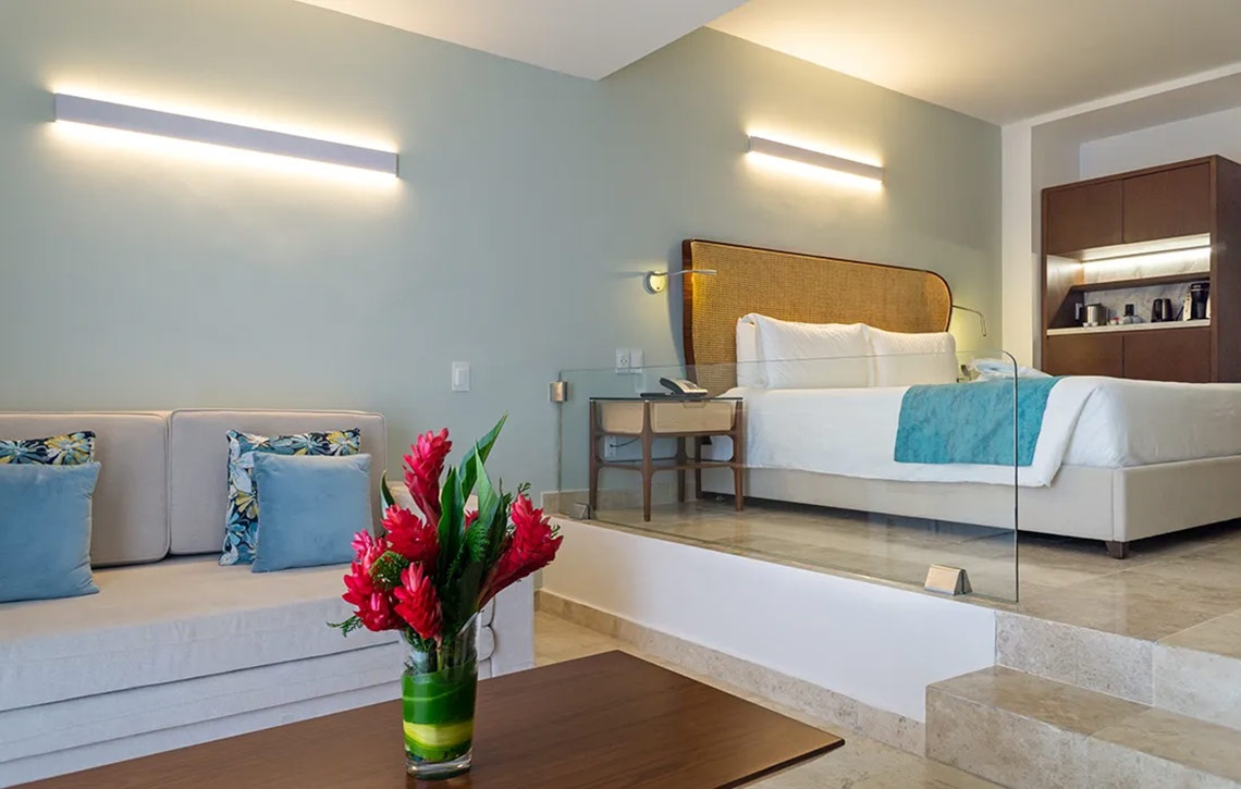 Elegant hotel room with a king-size bed and sofa at Sunset Royal Beach Resort.