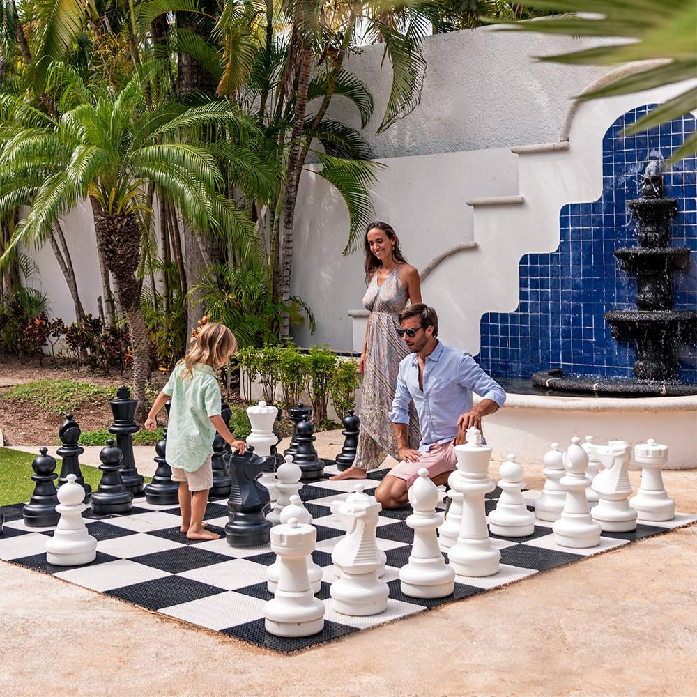 Familia jugando ajedrez gigante en Sunset World Resorts.