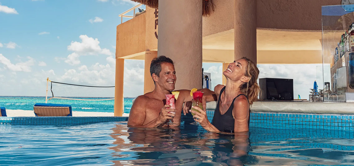 Pareja disfrutando bebidas en la piscina de Sunset Fishermen Beach Resort