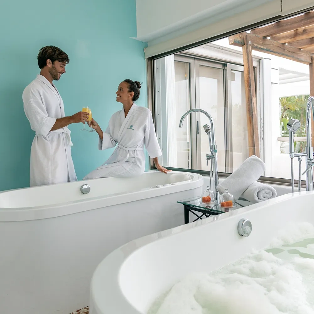 Pareja brindando en bañera doble en Sunset World Resorts: Corporativa.