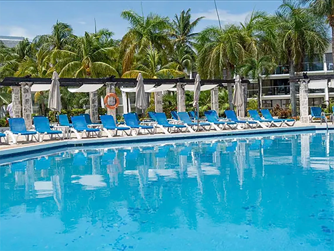 Ocean Spa Hotel: Poolside lounge chairs with palm trees.