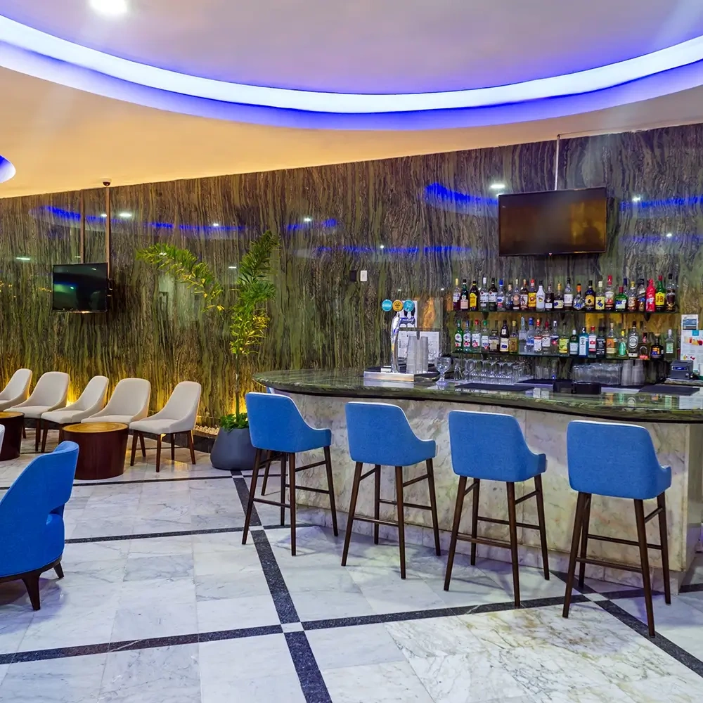 Sunset World Resorts: Corporativa lounge bar with blue chairs & marble floor.