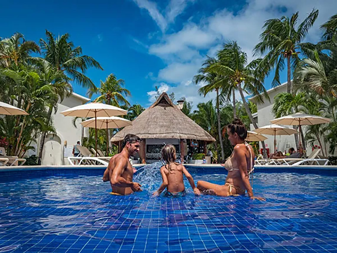 Familia disfrutando la piscina en Laguna Suites | Página Oficial. Vacaciones familiares.
