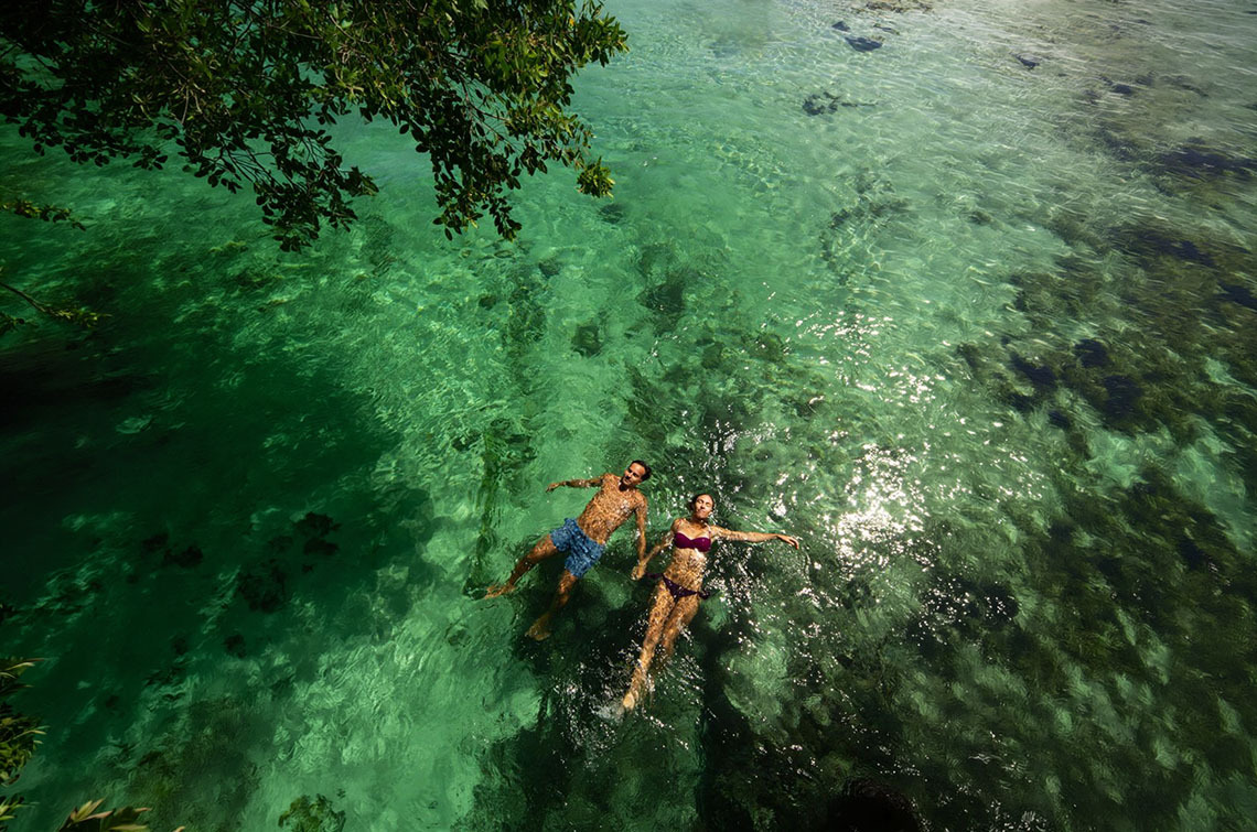 Pareja nadando en aguas cristalinas, ideal para Sunset World Resorts: Corporativa.