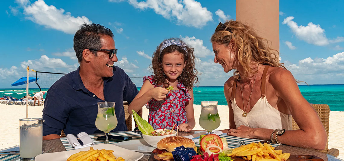 Familia disfruta comida en Sunset Fishermen Beach Resort | Página Oficial.