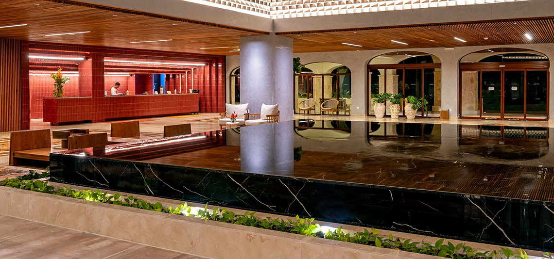 Hacienda Tres Rios: Modern lobby with reception, seating, and reflective pool.