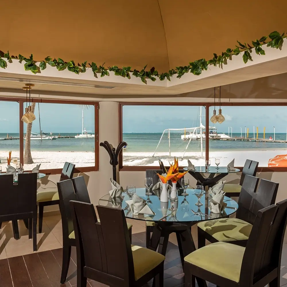Sunset World Resorts: Corporativa dining room with ocean view and beach.
