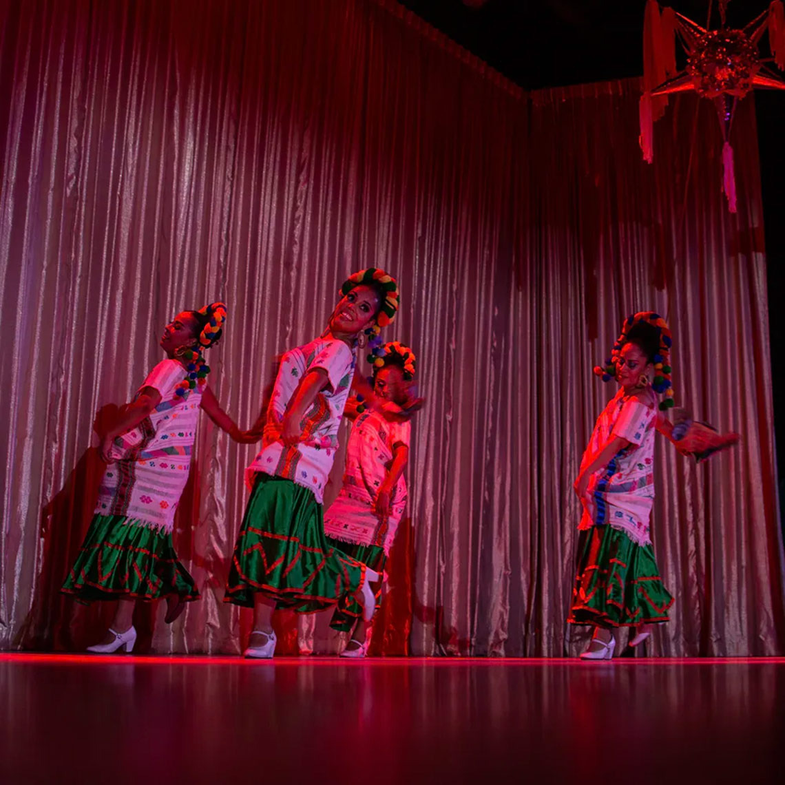 Hacienda Tres Rios dancers in traditional attire perform on stage.