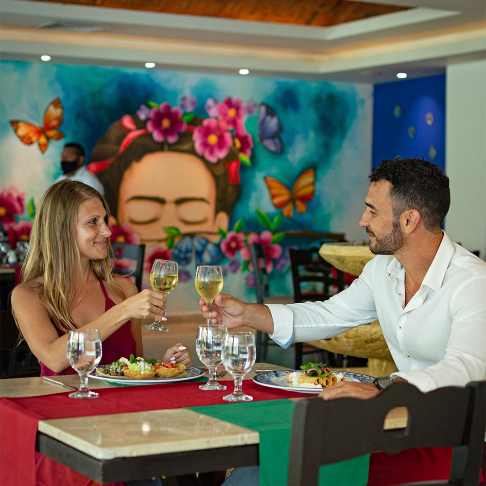 Sunset World Resorts: Corporativa restaurant with Frida Kahlo mural and blue accents.