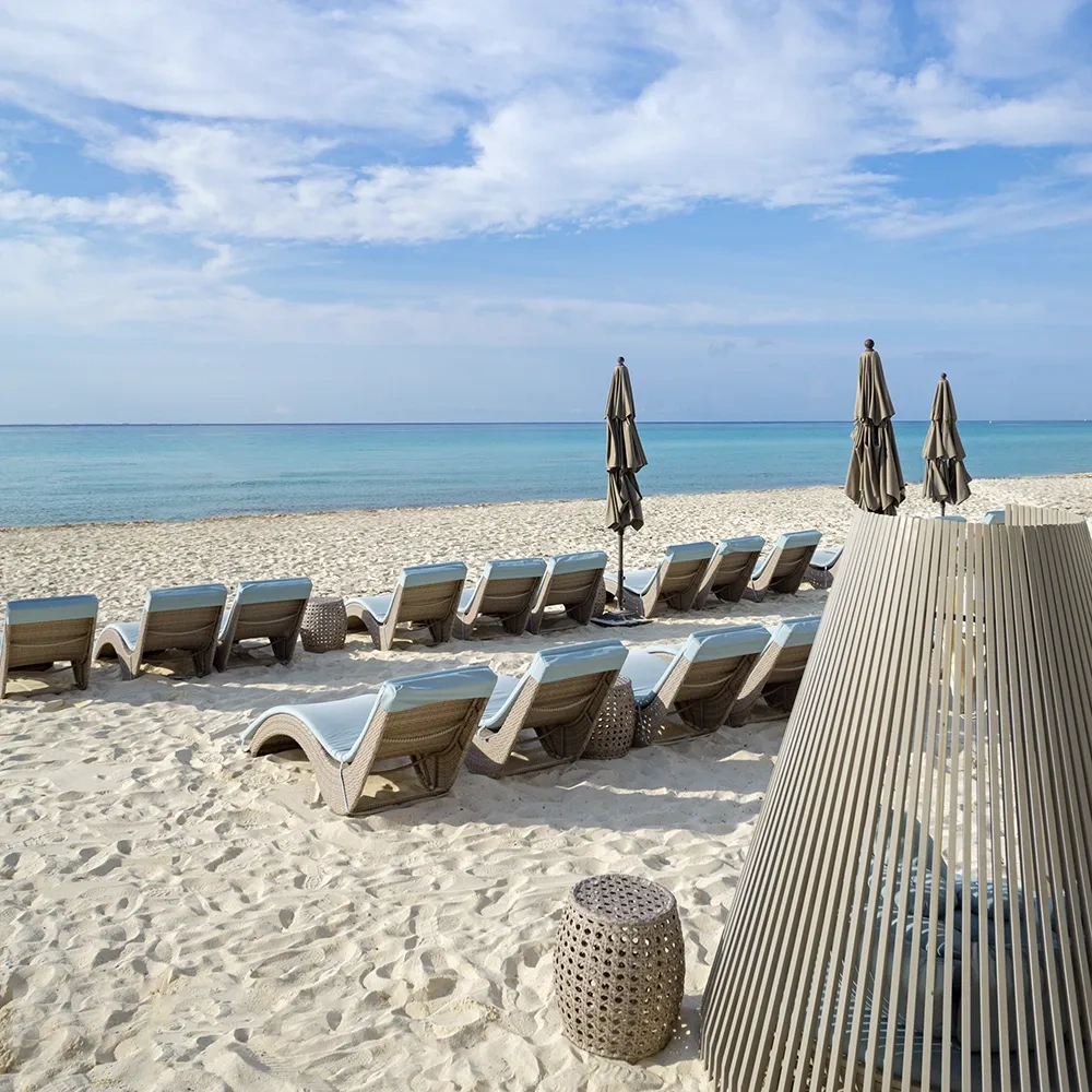 Caribe de Sunset World Resorts: Corporativa, sillas de playa y sombrillas junto al mar turquesa.