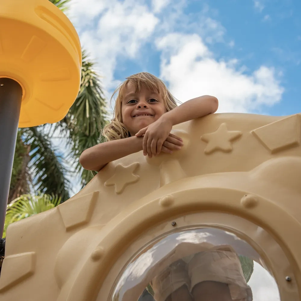 Niño sonriendo en un tobogán del resort Sunset World Resorts: Corporativa.