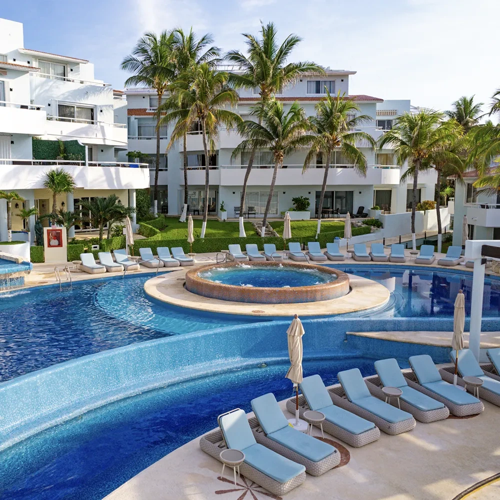 Sunset World Resorts: Corporativa: Piscina refrescante con tumbonas y palmeras.