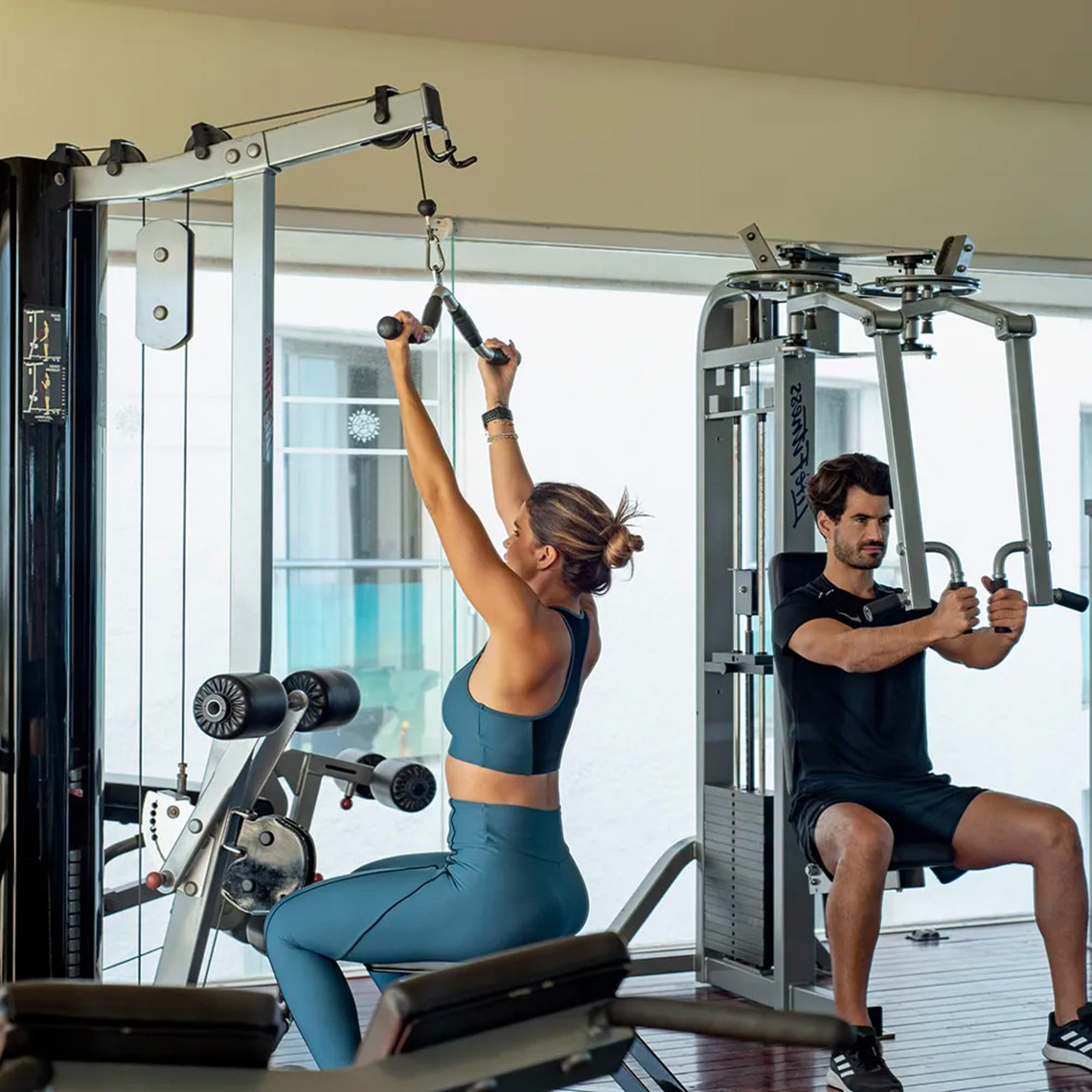 Sunset Royal Beach Resort guests enjoy a couple's workout at the fitness center.