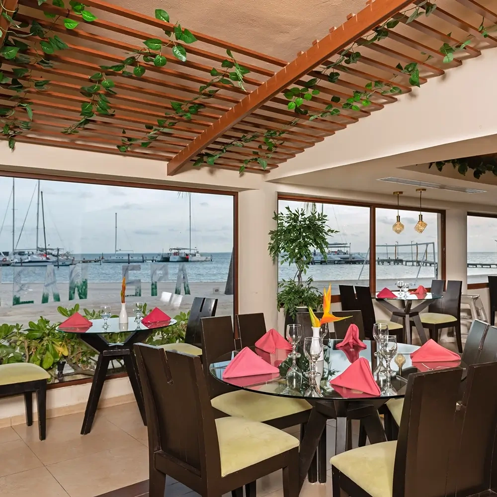 Sunset World Resorts: Corporativa, dining room overlooking the ocean with tables set for dinner.