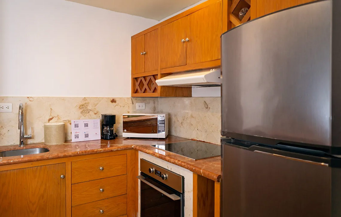 Cocina completa en Sunset Fishermen Beach Resort. Refrigerador, estufa, microondas y más.