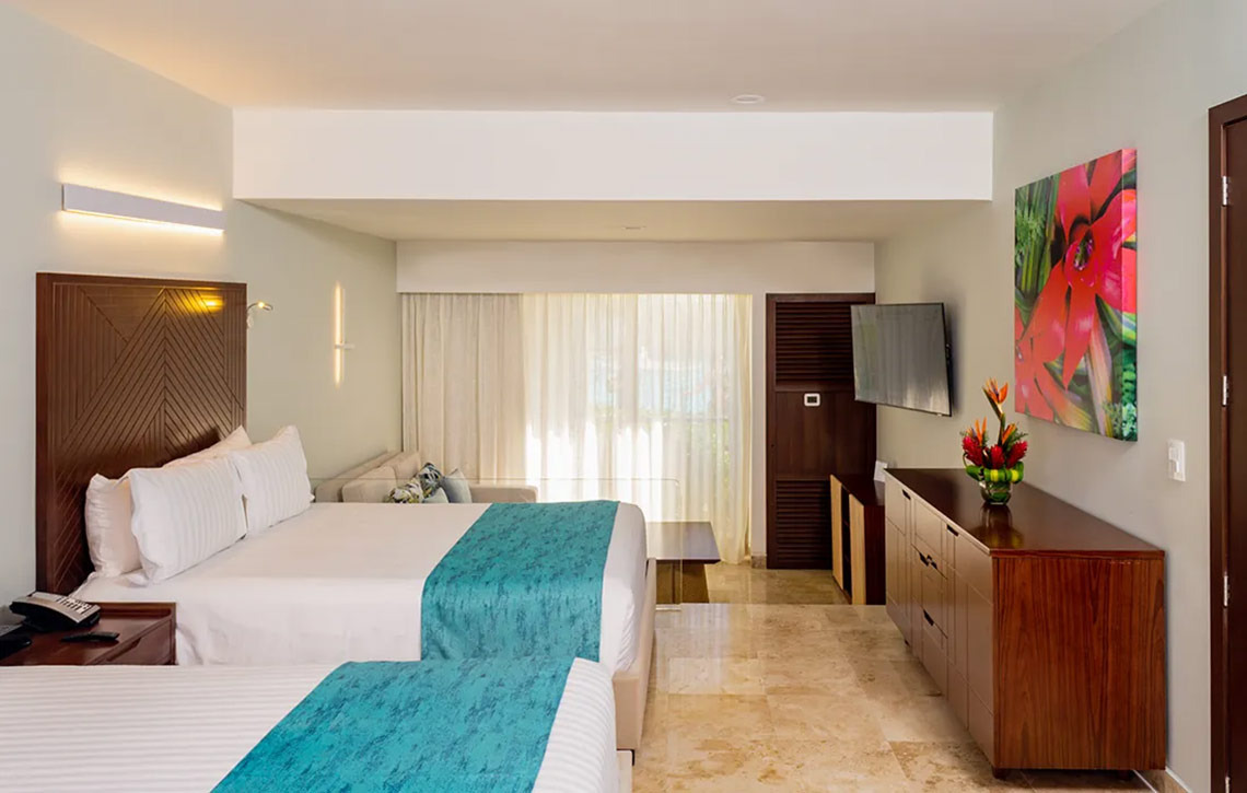 Sunset Royal Beach Resort: Room with two beds, tropical art, and wood dresser.