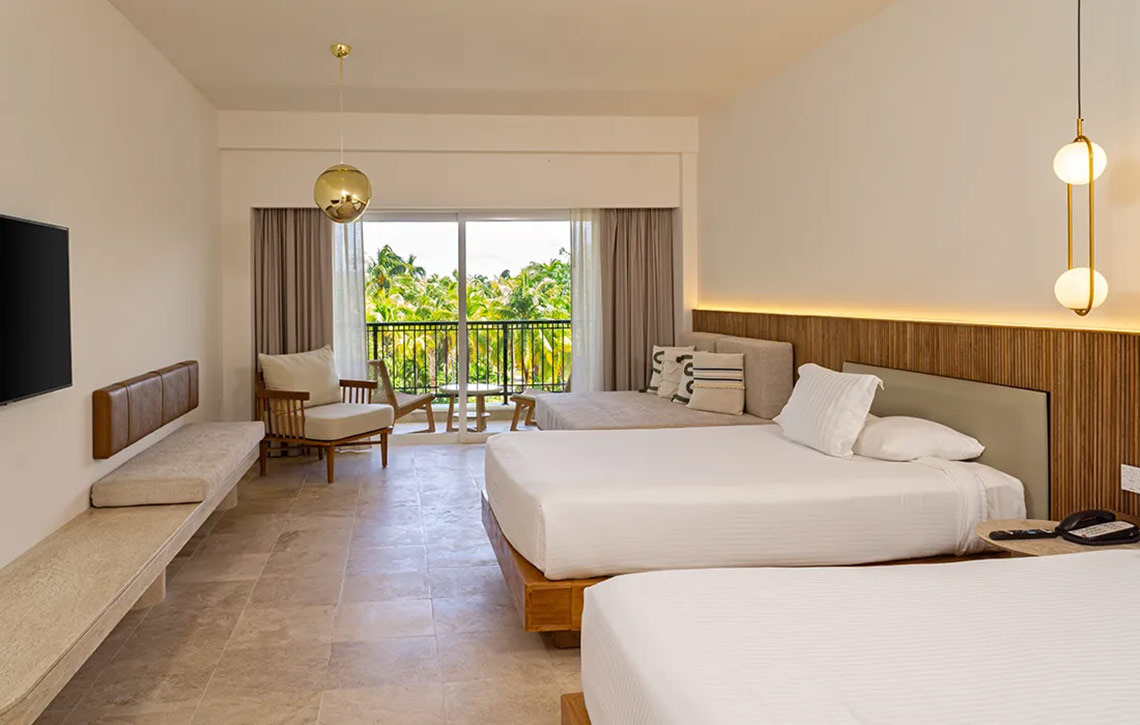 Spacious Hacienda Tres Rios hotel room with two beds, a balcony view, and modern decor.