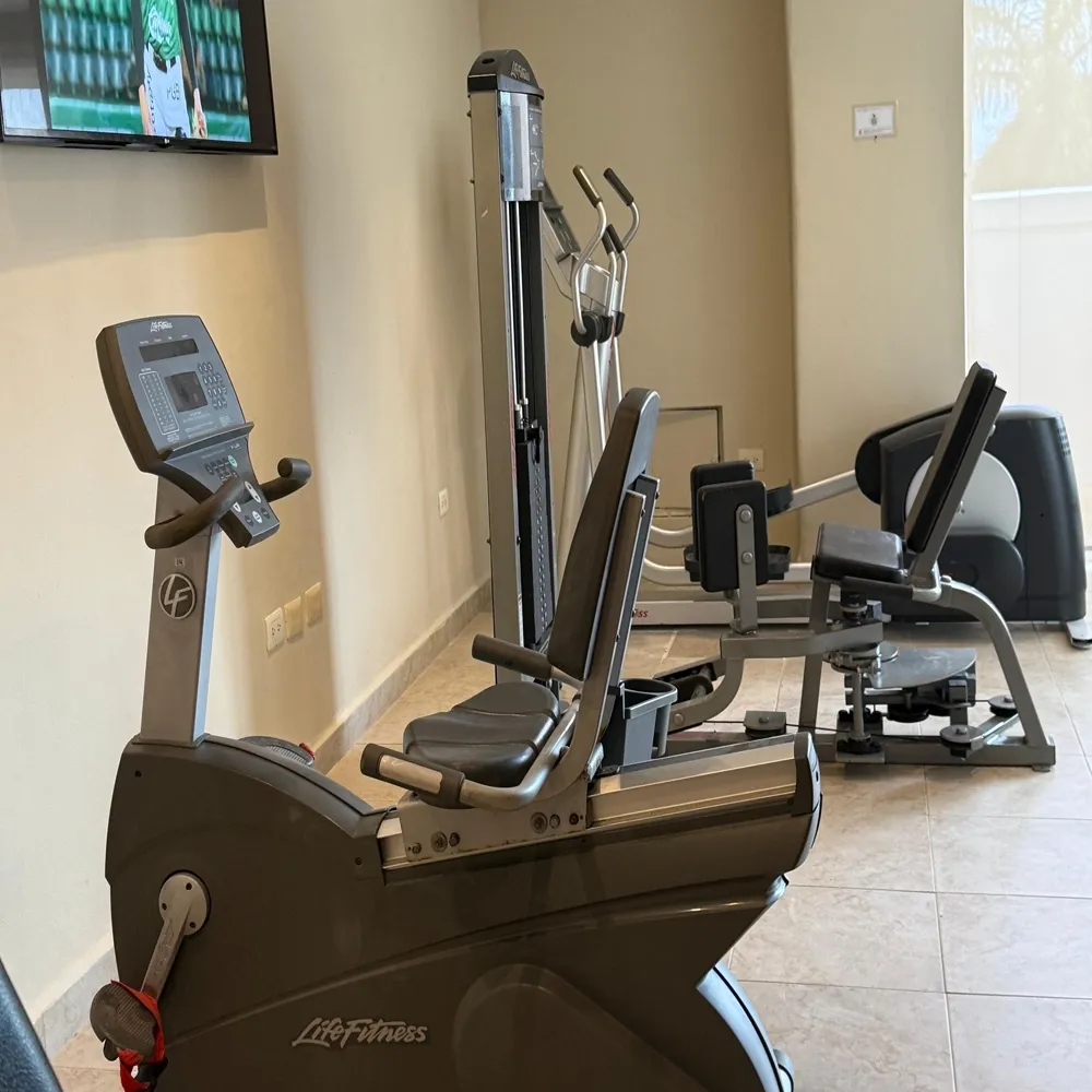 Sunset World Resorts: Corporativa gym with recumbent bikes, weight machines, and elliptical.