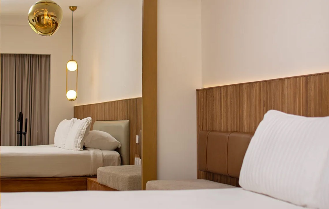 Modern Hacienda Tres Rios hotel room with comfortable beds & stylish lighting.