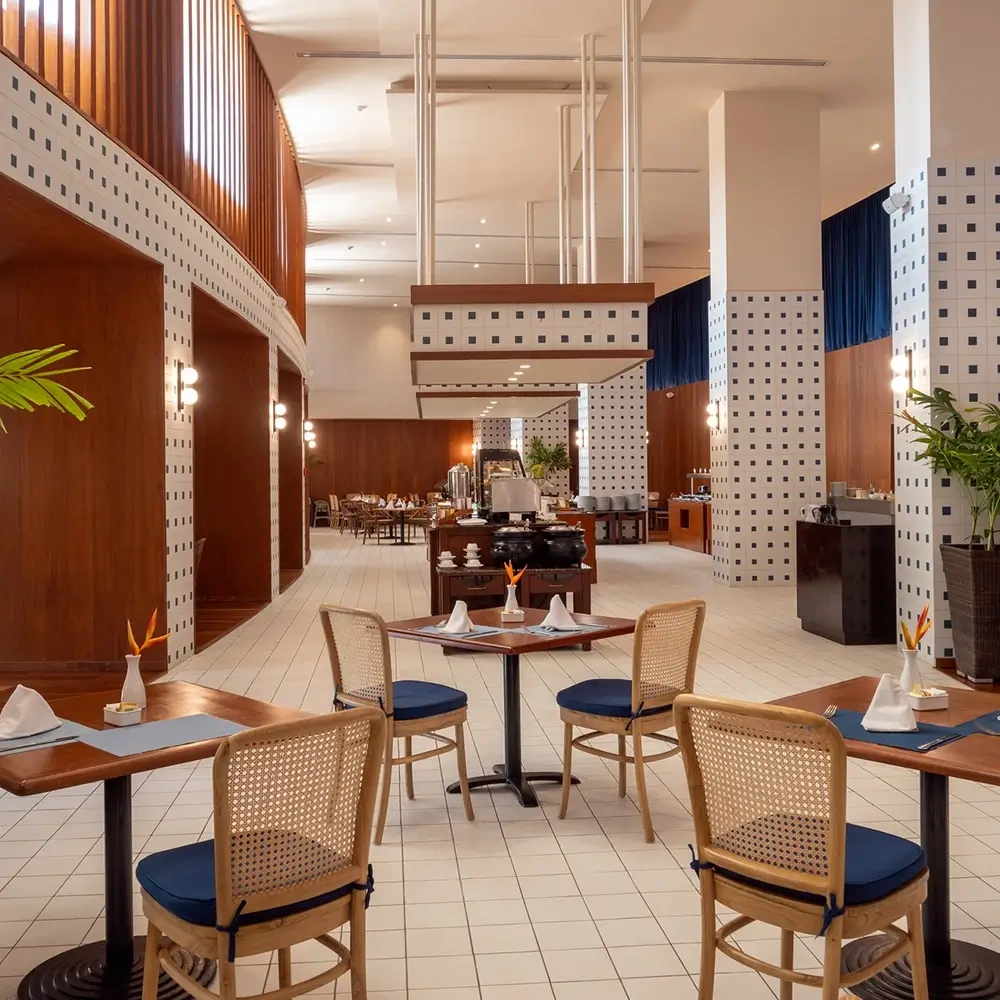 Elegant hotel dining room with tables and chairs, featuring wood accents and tiled walls. Sunset Hotels Collection: Corporativa