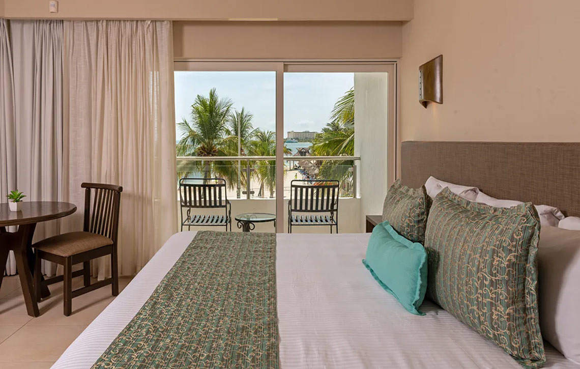 Ocean Spa Hotel room with king bed, balcony, and ocean view.