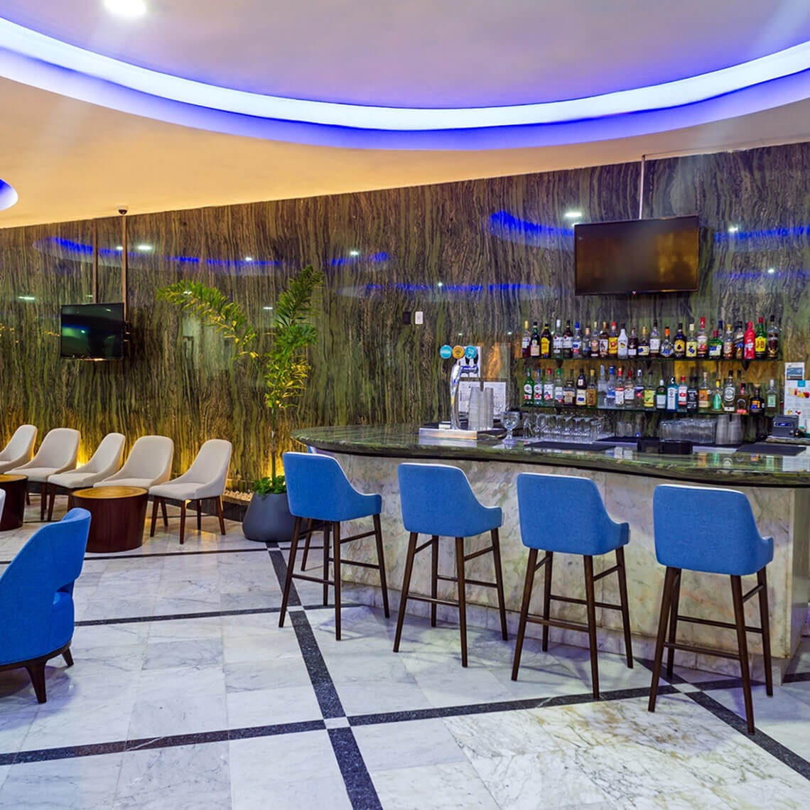 Sunset Royal Beach Resort bar with blue stools and marble bar.