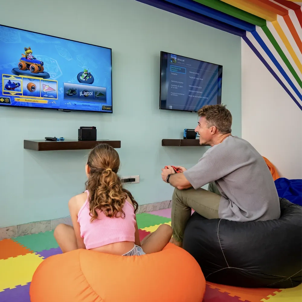 Adultos y niños disfrutan en Sunset World Resorts: Corporativa sala de juegos.