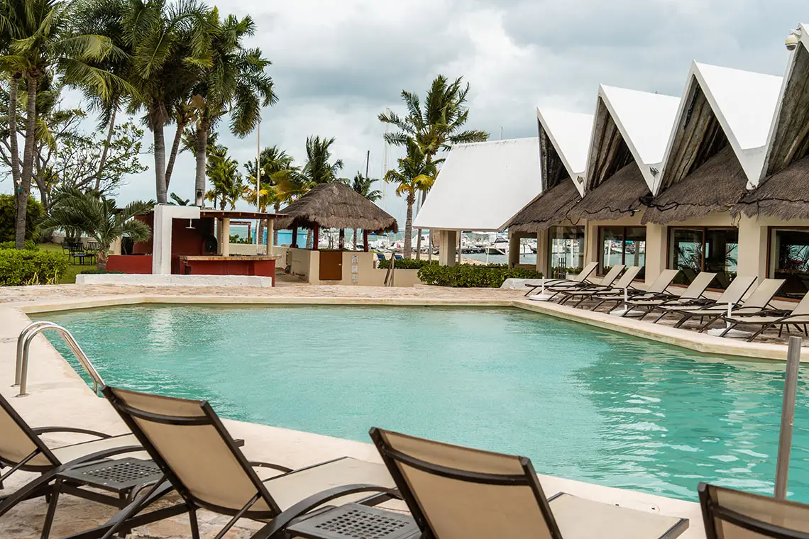 Resort swimming pool with lounge chairs and palm trees, ideal for Sunset Hotels Collection: Corporativa.