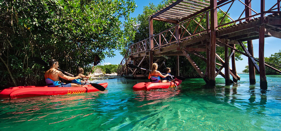 Hacienda Tres Rios: Kayak through clear waters under a wooden bridge.