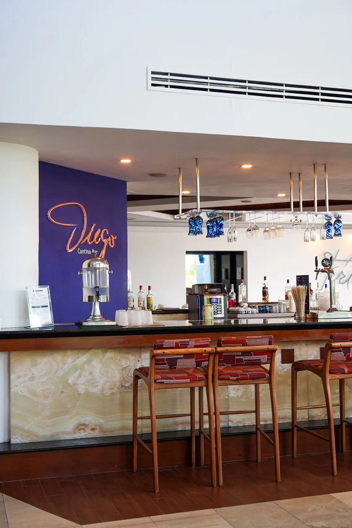 Sunset World Resorts: Corporativa bar with green wall and bar stools.