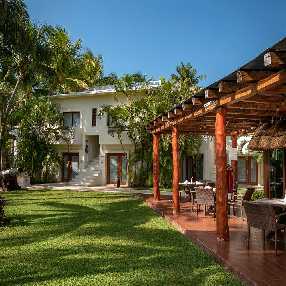 Tropical hotel with outdoor dining area and palm trees Sunset Hotels Collection: Corporativa