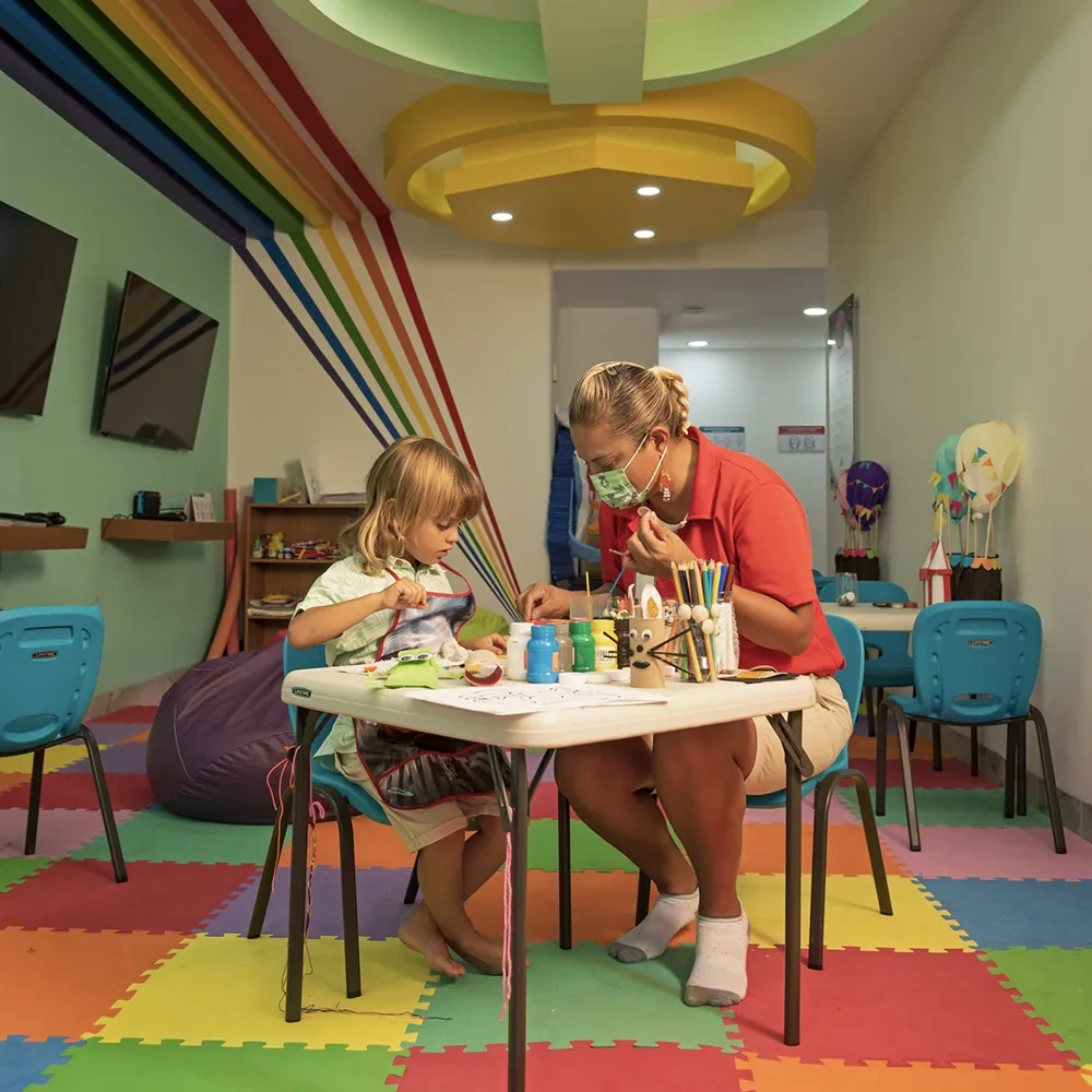 Diversión en Sunset World Resorts: Niños y adultos disfrutan videojuegos.