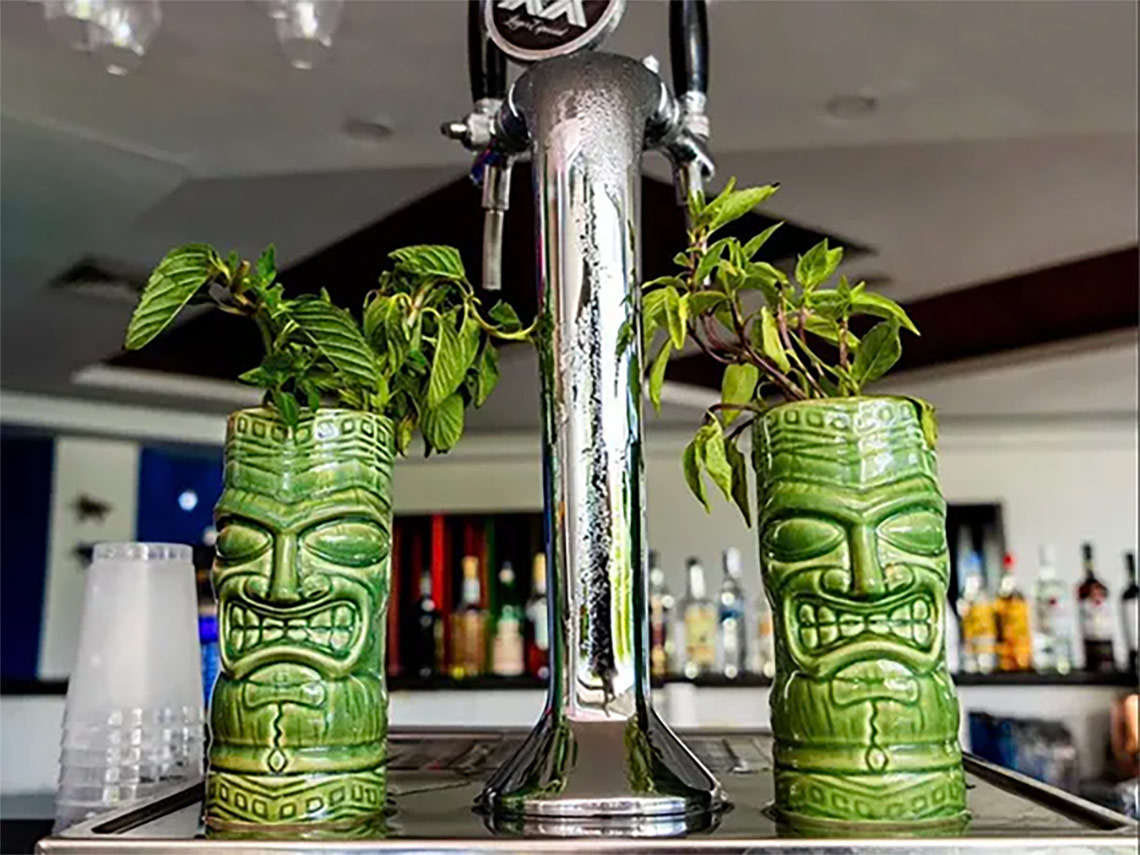Tiki planters with plants flank a beer tap at the Ocean Spa Hotel.