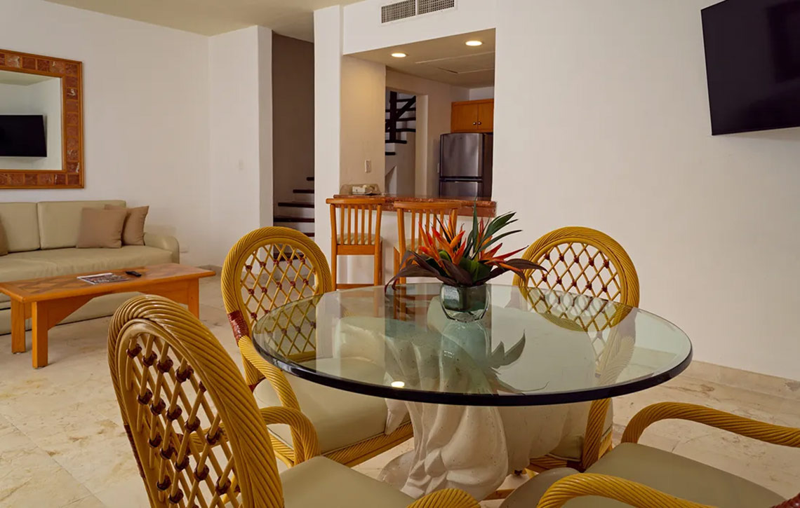 Comedor de cristal con sillas de mimbre en Sunset Fishermen Beach Resort.