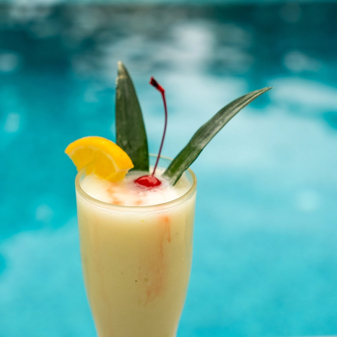 Tropical cocktail with cherry and pineapple leaf, Hacienda Tres Rios | Official Page.