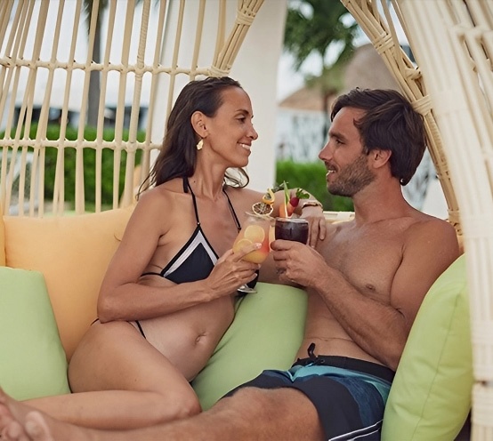 Pareja disfrutando cócteles en Sunset World Resorts: Corporativa.