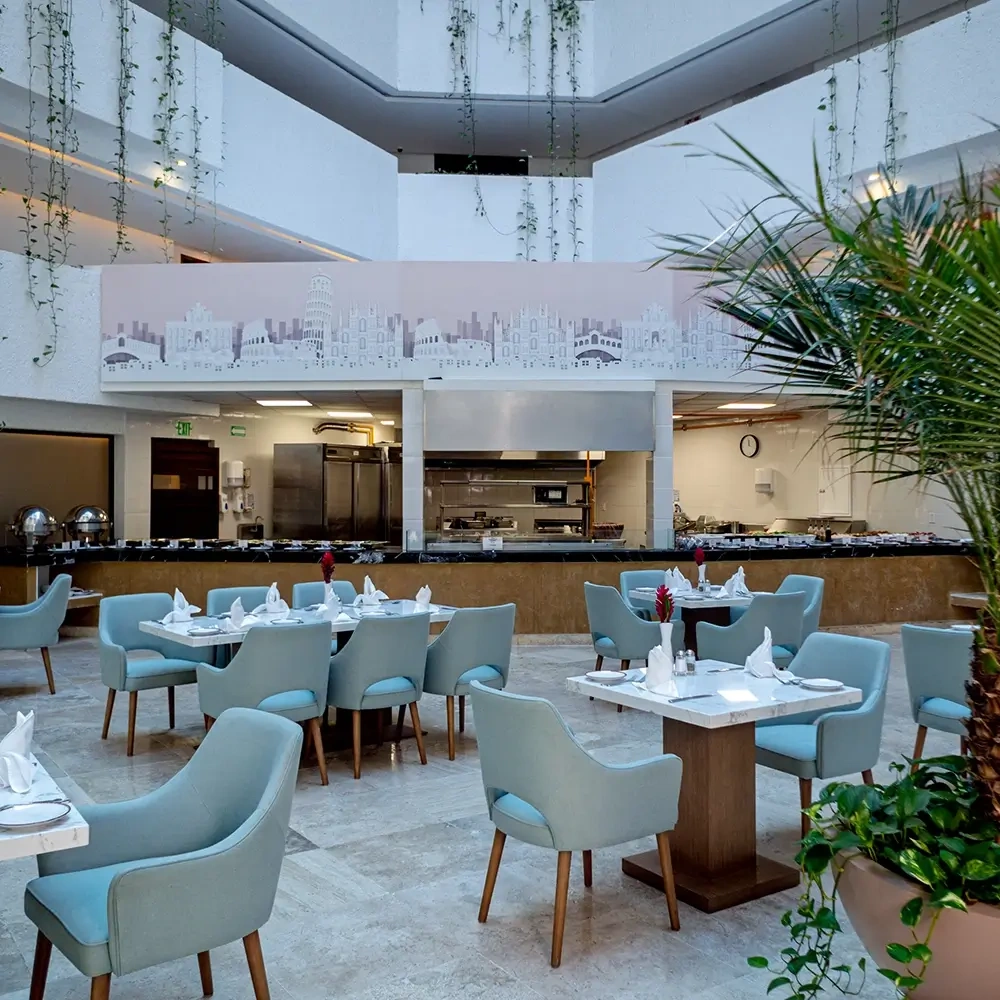 Sunset World Resorts: Corporativa dining area with light blue chairs and buffet setup.