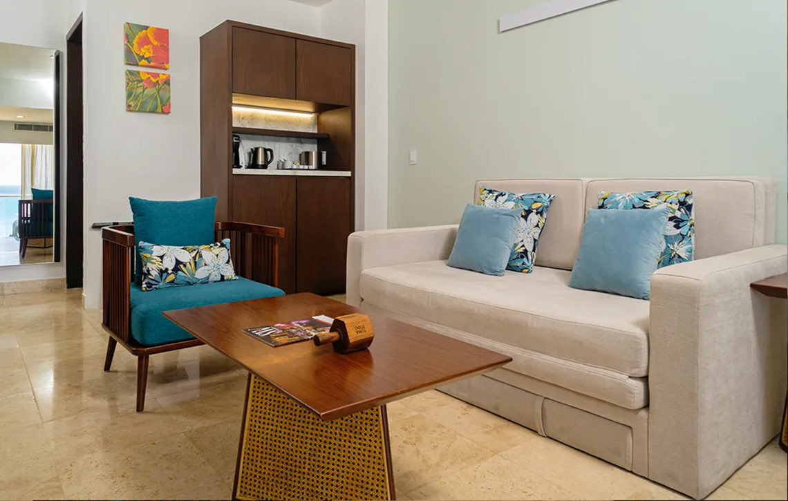 Sunset Royal Beach Resort: Chic living area with armchair, sofa, and coffee table.