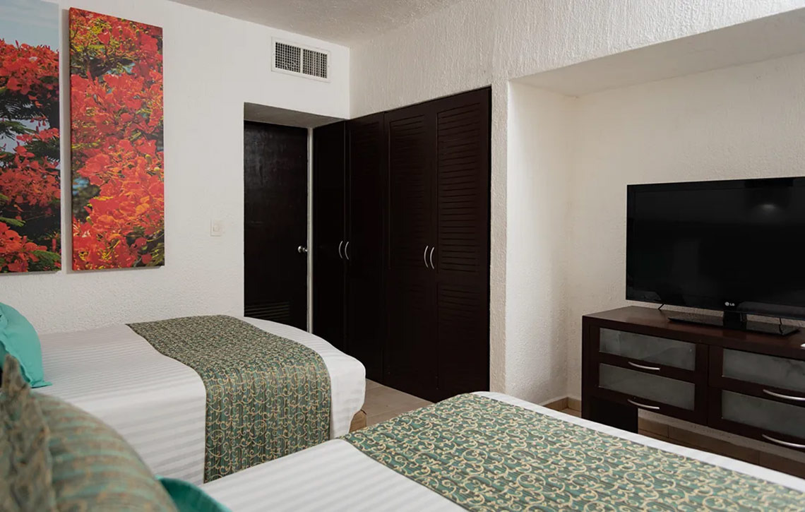 Habitación doble con arte floral y TV en Laguna Suites | Página Oficial.