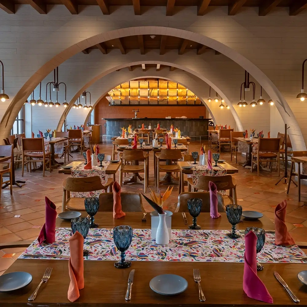 Restaurant dining area with arched ceilings and colorful table settings Sunset World Resorts: Corporativa