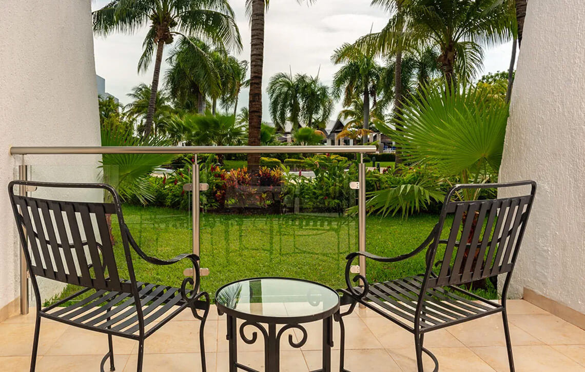 Ocean Spa Hotel balcony with chairs overlooking tropical gardens and palm trees