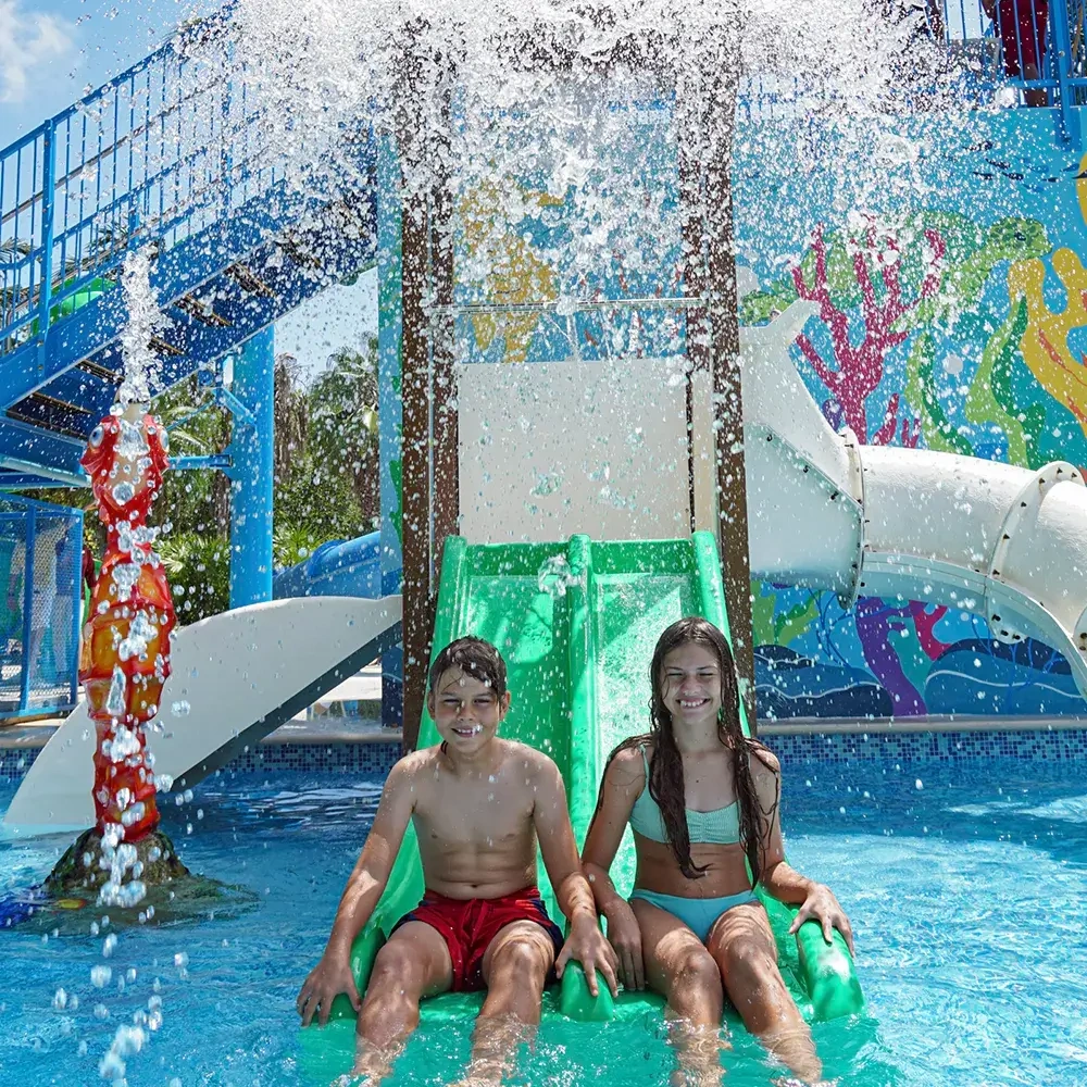 Two smiling kids on a water slide at a hotel Sunset Hotels Collection: Corporativa