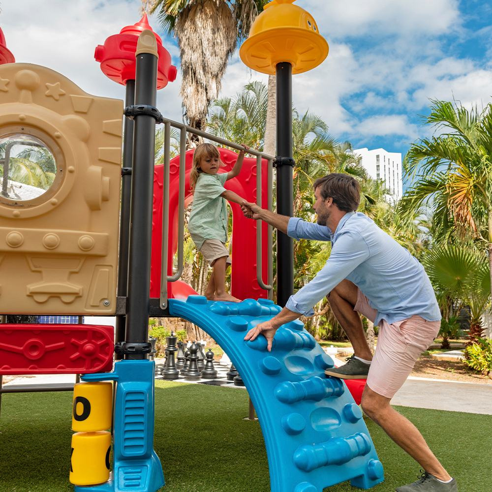Adultos y niños disfrutan en Sunset World Resorts: Corporativa sala de juegos.
