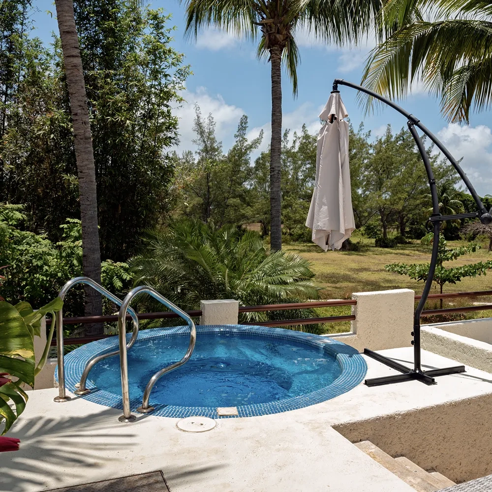 Jacuzzi al aire libre con vistas tropicales, ideal para relajarse en Sunset World Resorts: Corporativa.