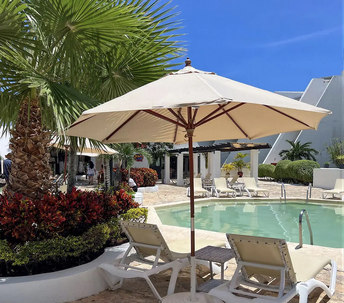 Resort swimming pool with lounge chairs and palm trees, ideal for Sunset Hotels Collection: Corporativa.