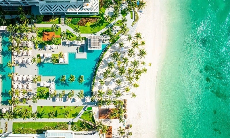 a large swimming pool surrounded by palm trees and buildings